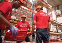 Purina employees working together in the manufacturing process